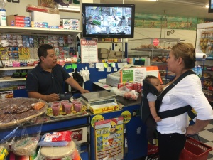 Francisco Aquino atiende a una consumidora en el supermercado La Yalalteca